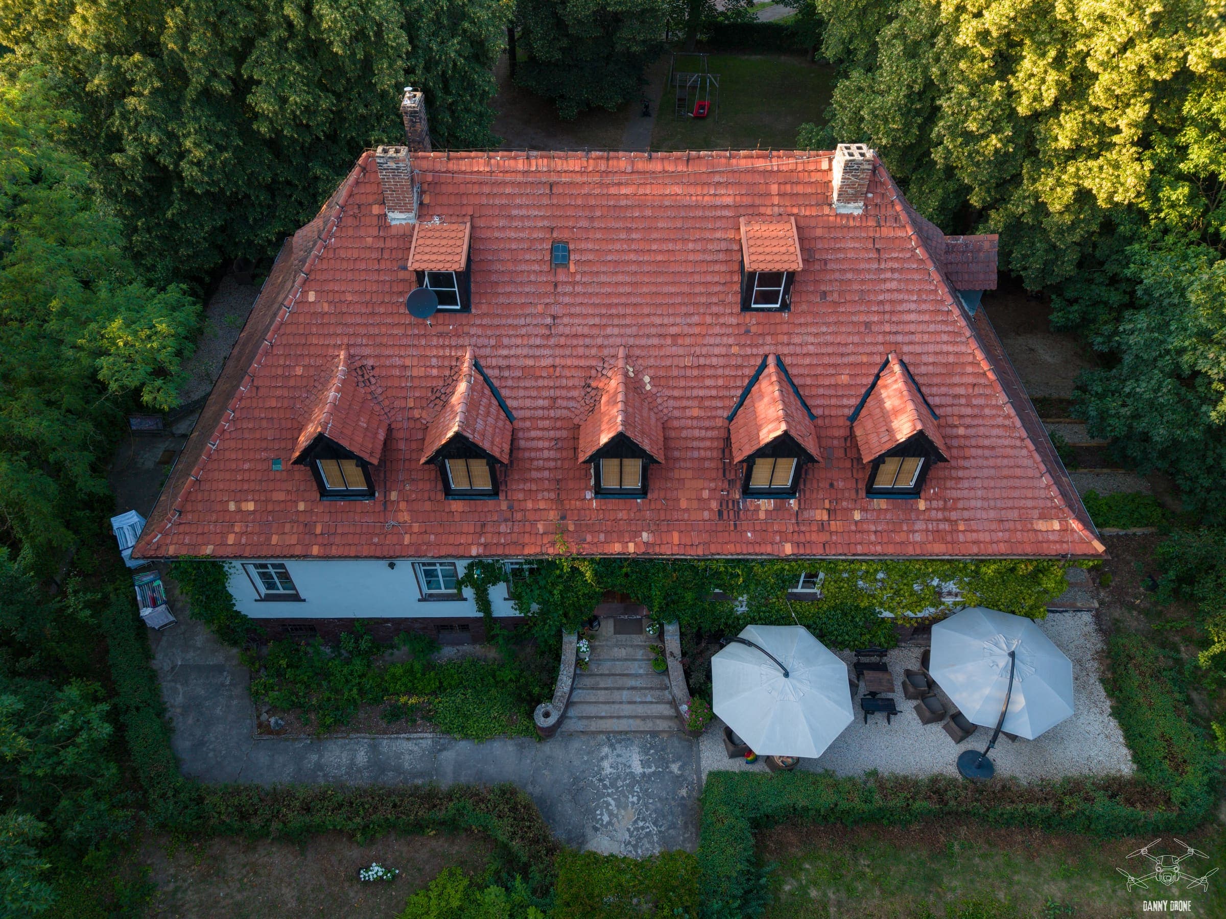 Pensjonat w Lubuskiem z drona - budynek z lukarnami i ogródek z parasolami
